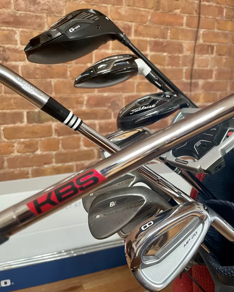 Freshly built irons and woods in a stand bag, with KBS steel shafts in the foreground